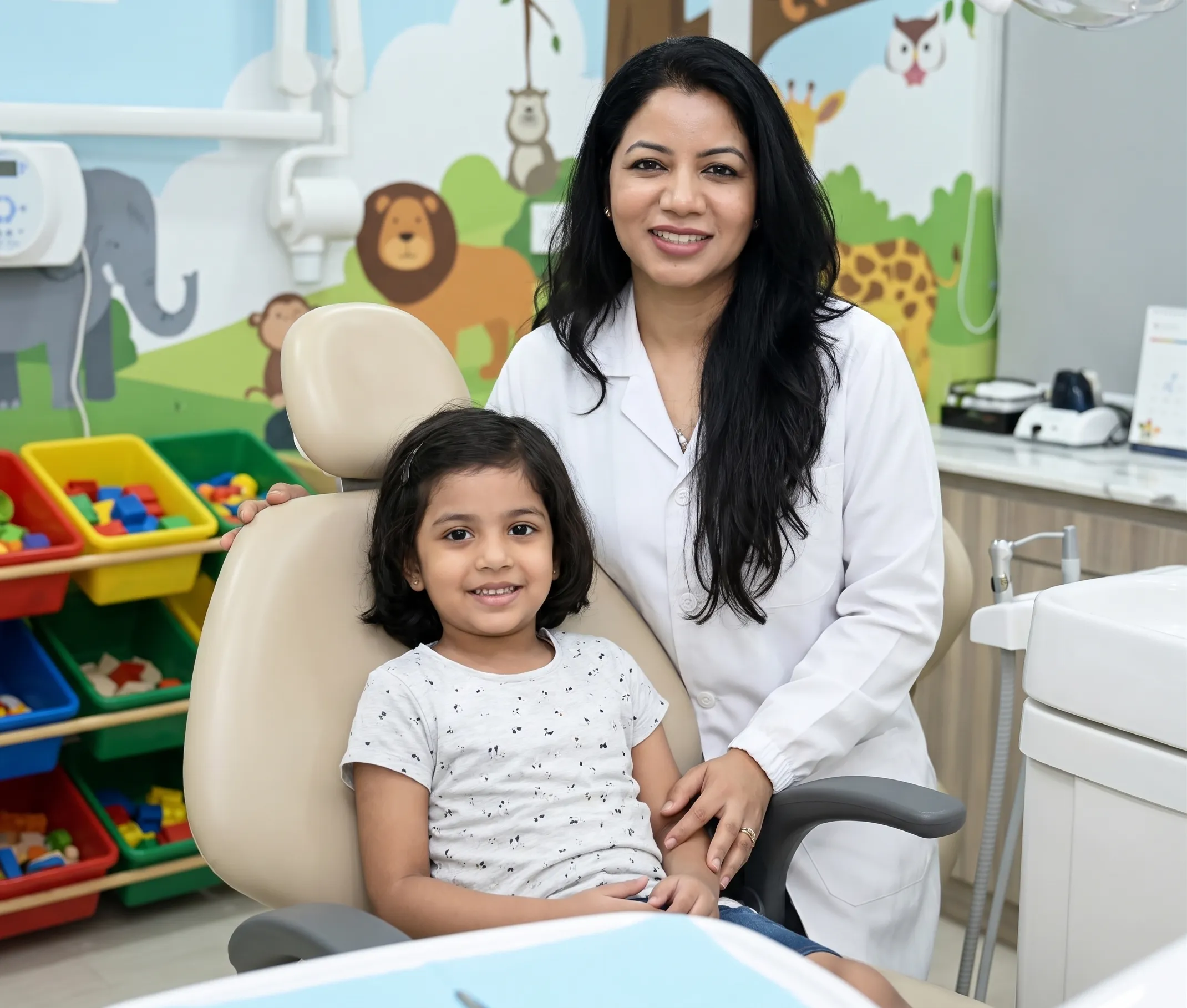 Dr. Revathi M. with a happy child in a pediatric dental clinic